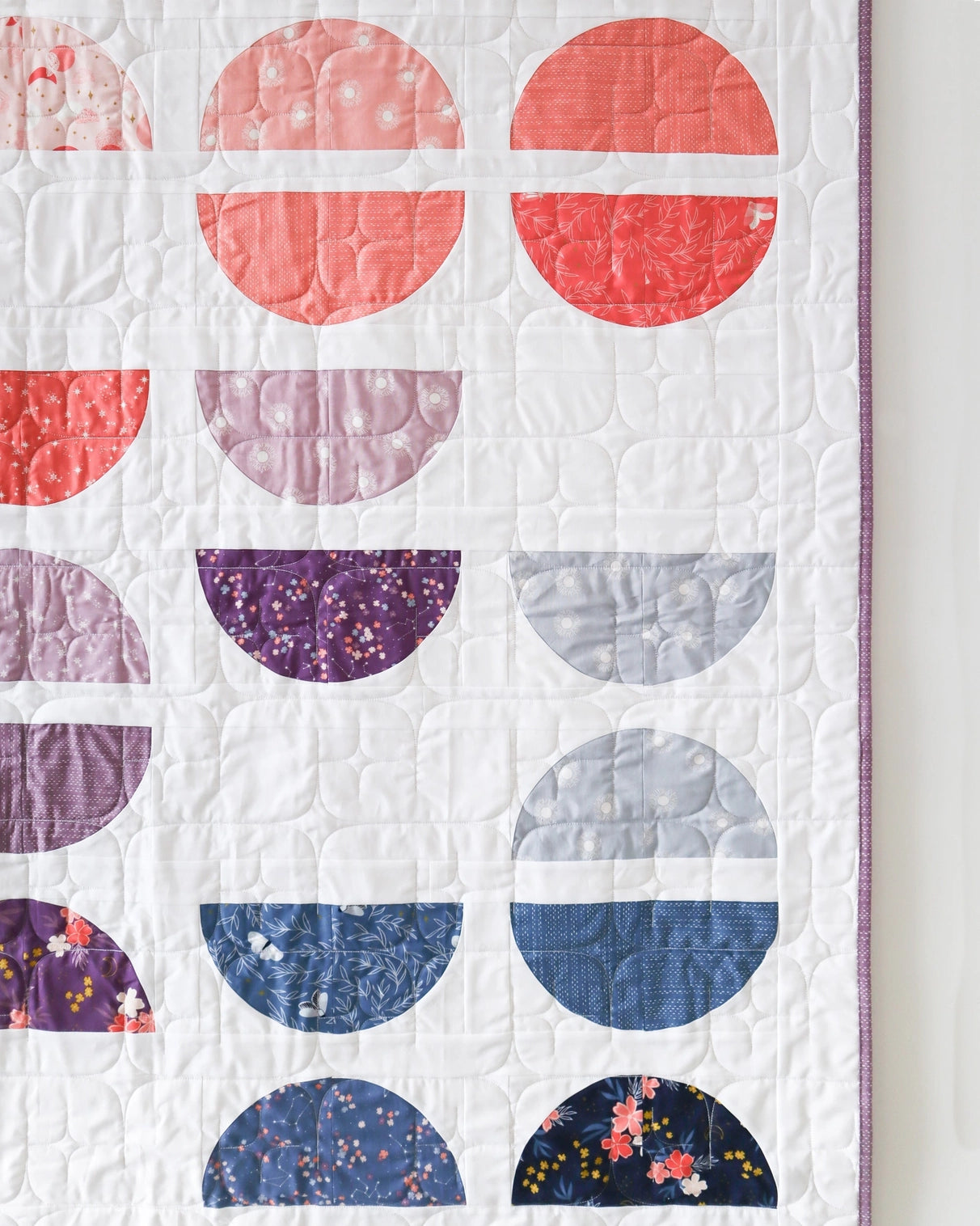Quilt with colorful geometric pattern on a white background