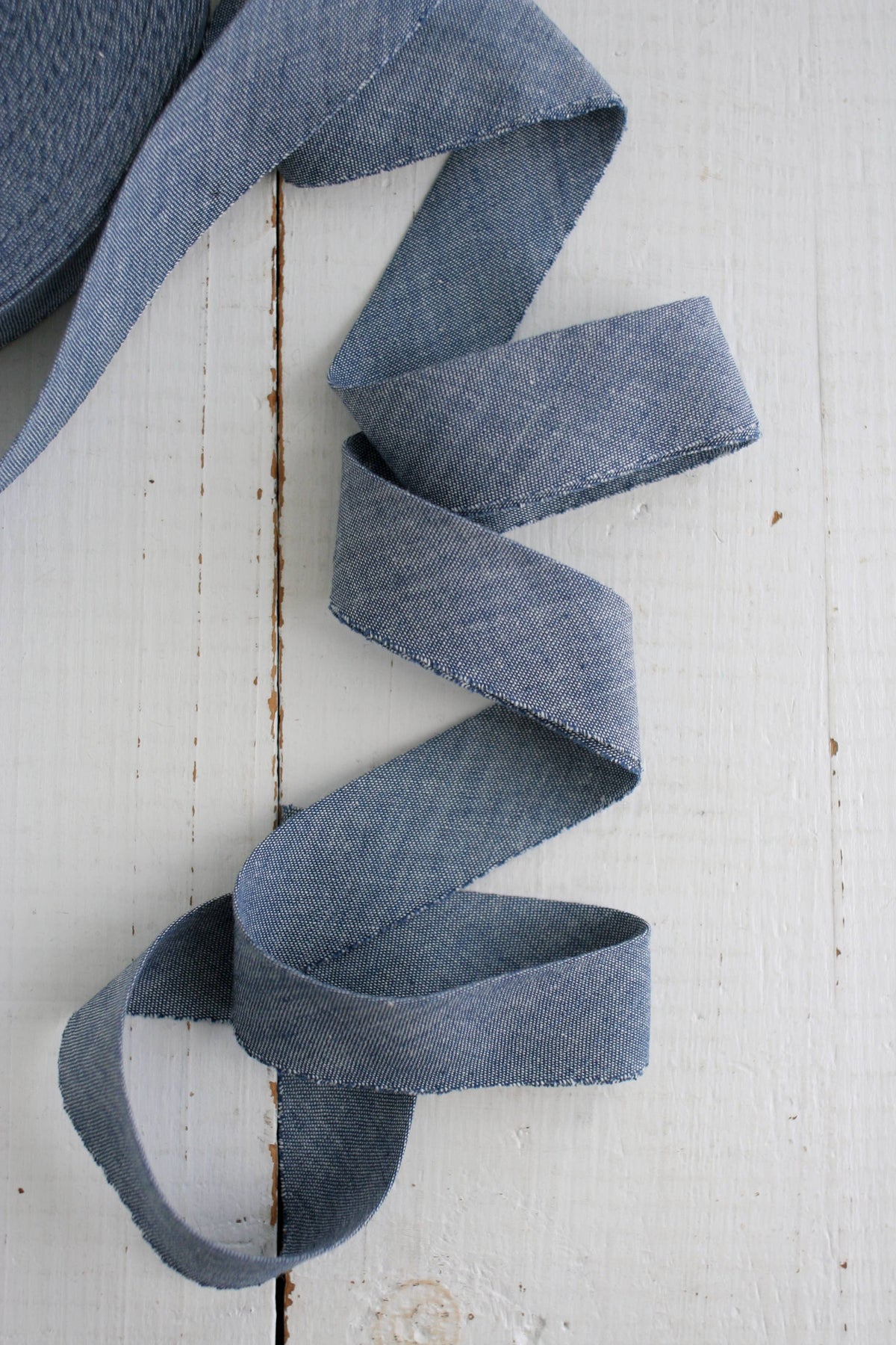 Blue denim ribbon on a white wooden surface