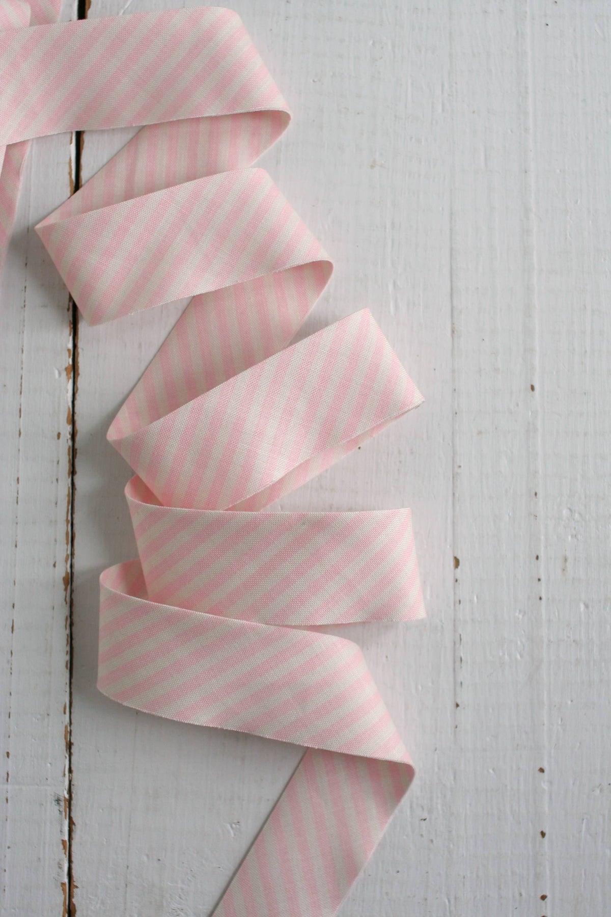 Pink striped ribbon on a light wooden surface