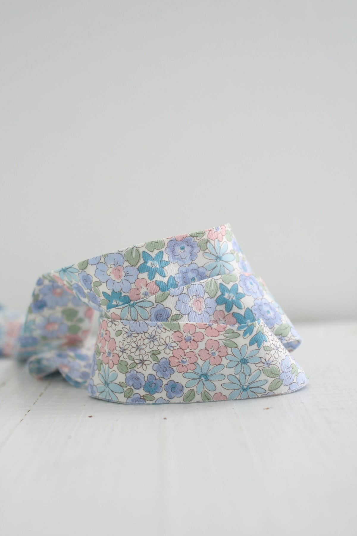 Floral-patterned fabric bias quilt binding on a white surface