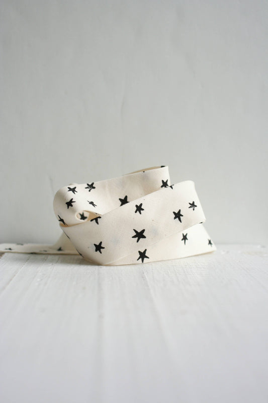 White bias trim with black star pattern on a light gray backgrounds 