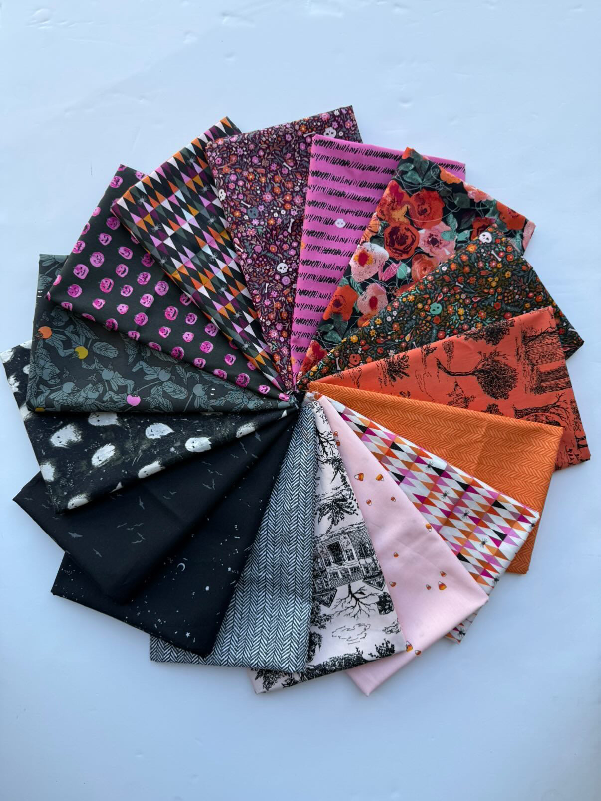 Collection of folded fabric samples with various patterns on a light blue background