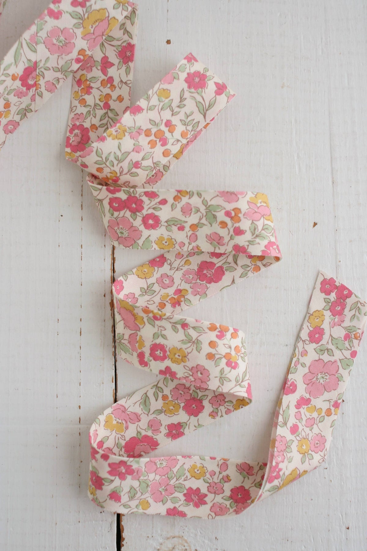 Floral bias quilt binding on a white wooden surface