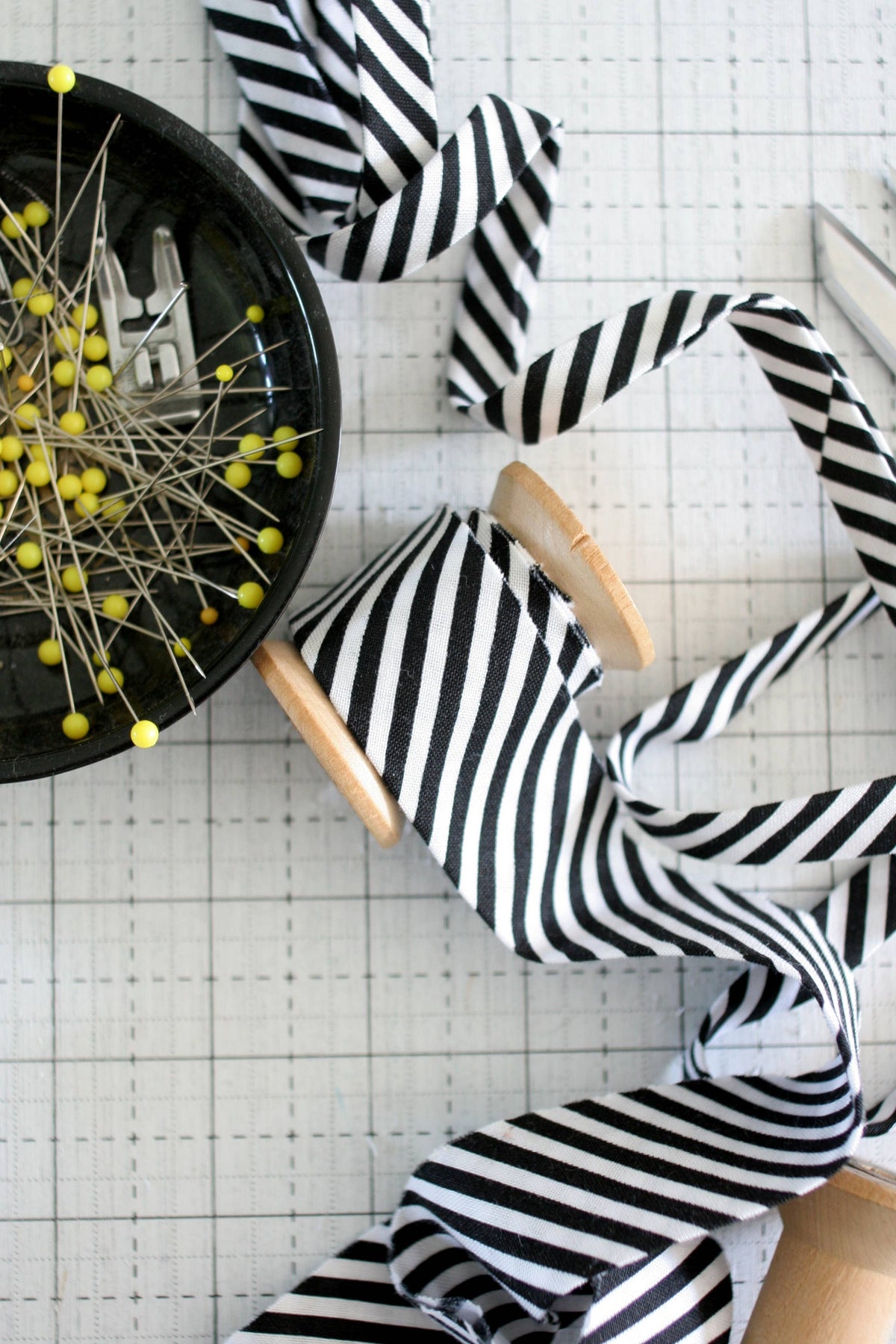 Black and white striped ribbon on a white grid background