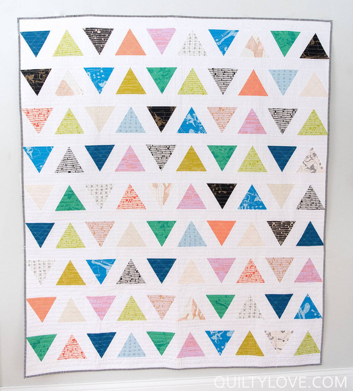 Colorful triangle pattern quilt on a white background