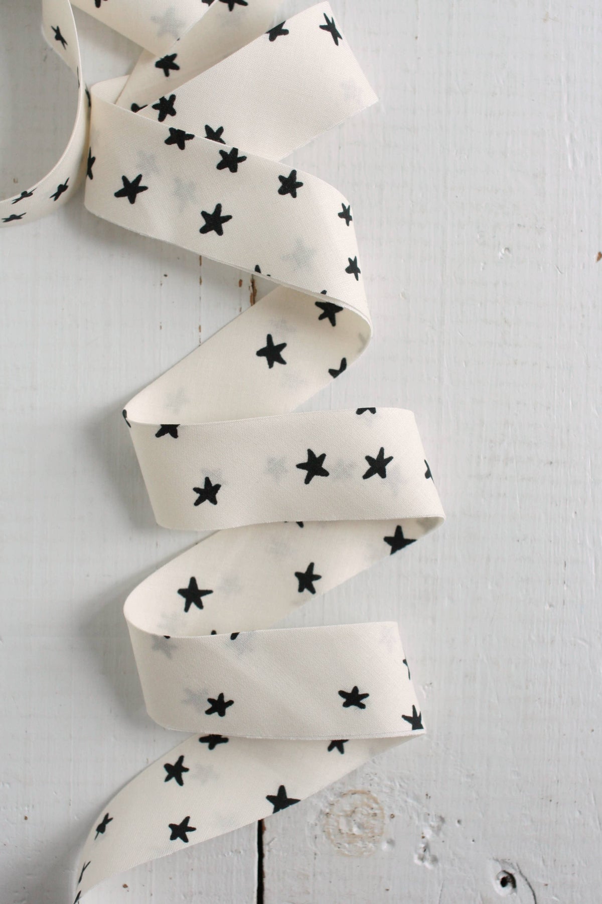 White fabric with black star patterns on a light gray background