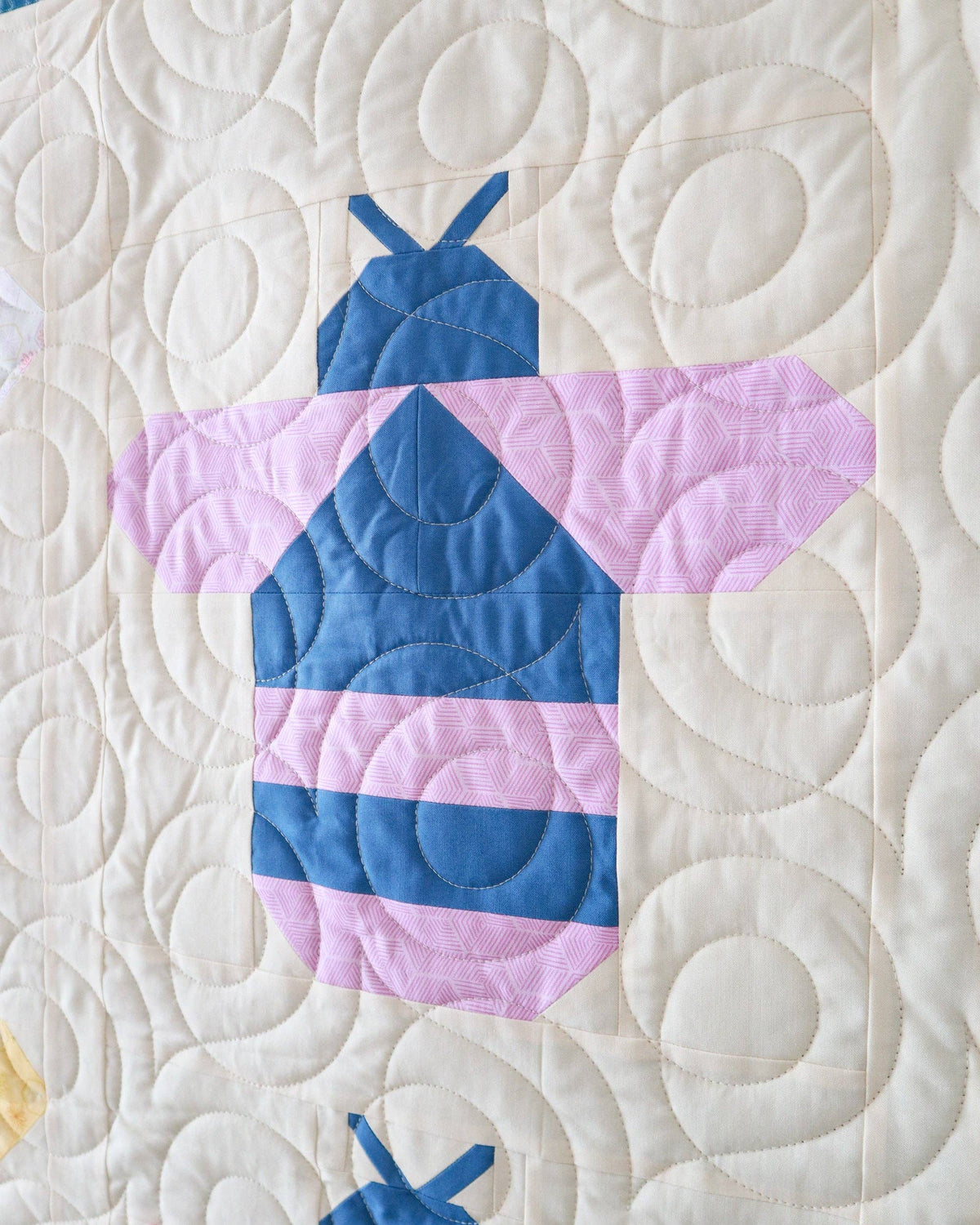 Quilt block with a blue and pink dress design on a white background