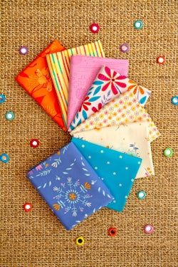 Collection of colorful fabric squares on a textured brown background