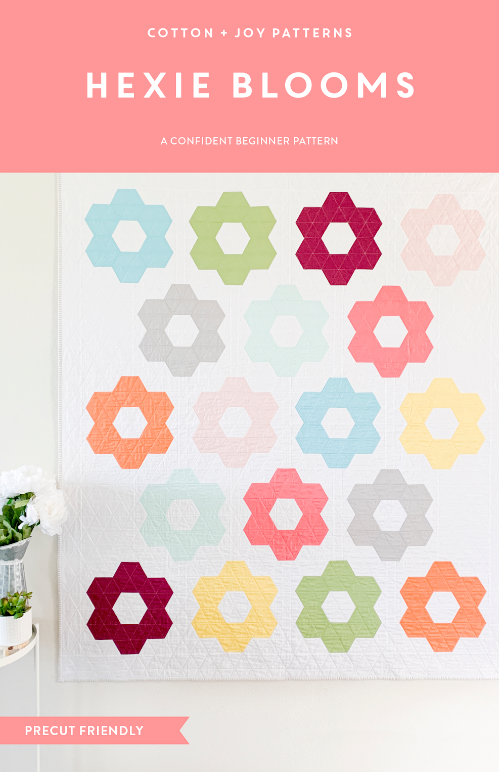 Hexagonal pattern quilt with colorful flowers on a white background, featuring the brand 'Cotton + Joy'.