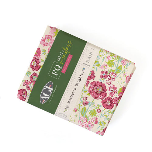 A folded fabric bundle from FQ Fabrics by Bari J, , featuring a floral pattern with pink, red, and green flowers on a cream background, wrapped in a dark green paper sleeve with a white ruler printed on the side.