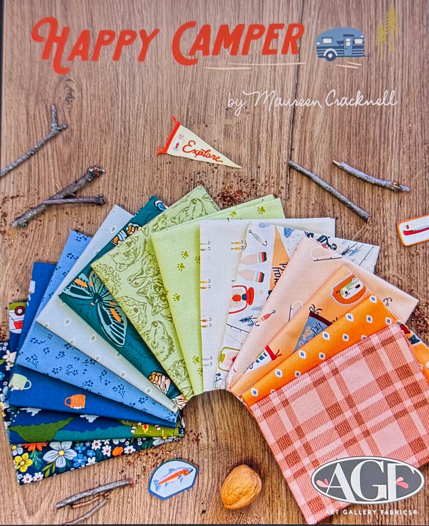 Collection of fabric swatches with 'Happy Camper' branding on a wooden background