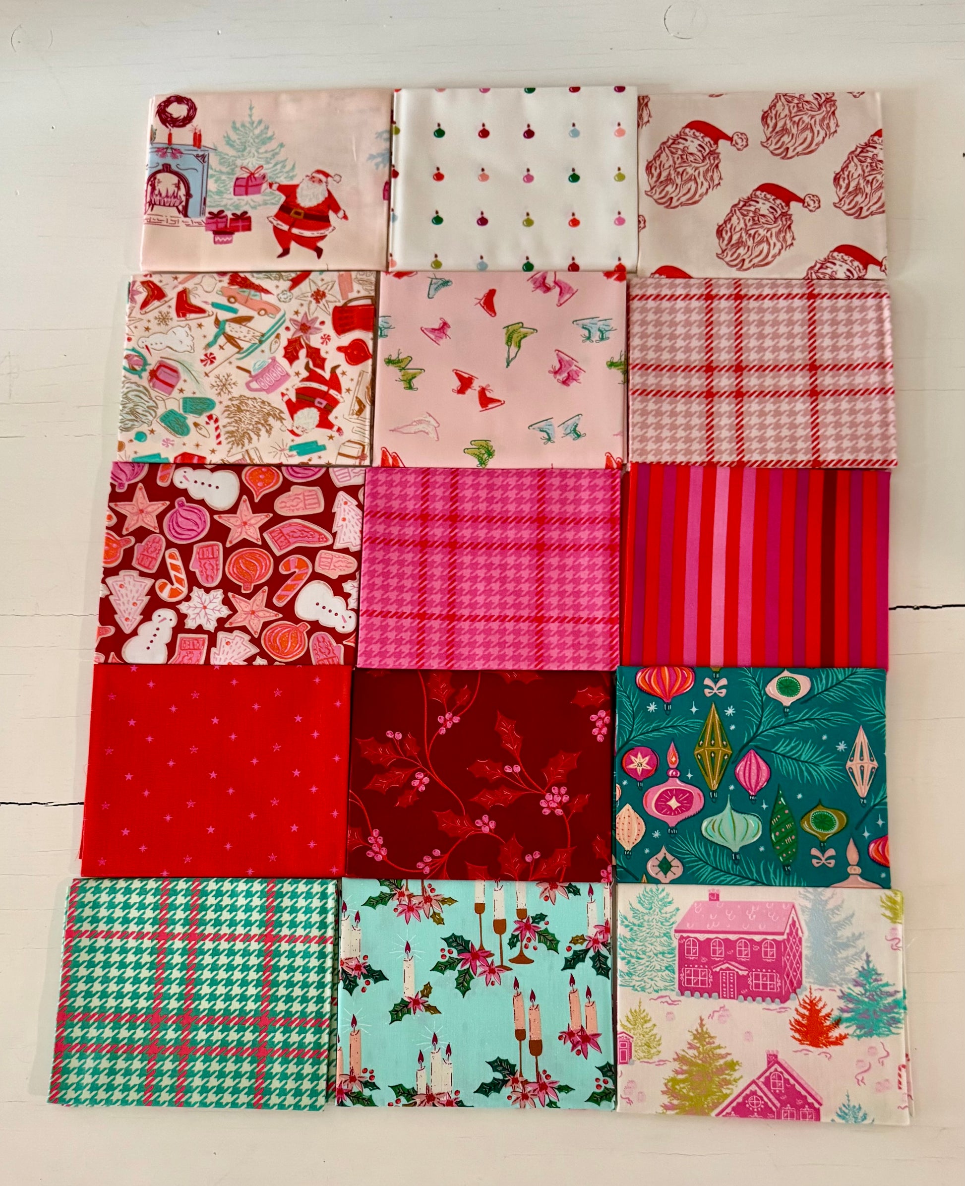 Squares of Christmas fabrics on a white table