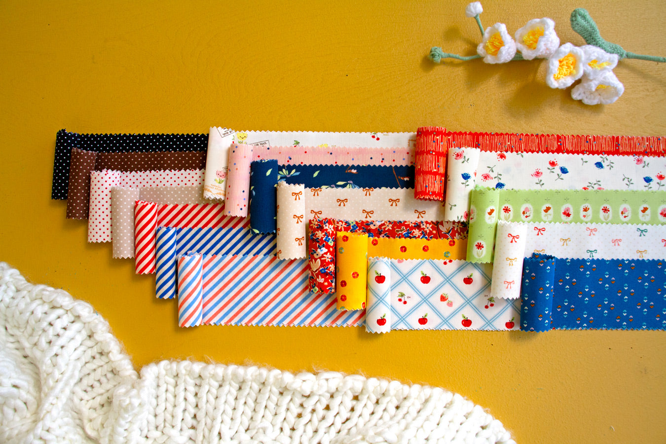 Collection of colorful fabric strips on a yellow background
