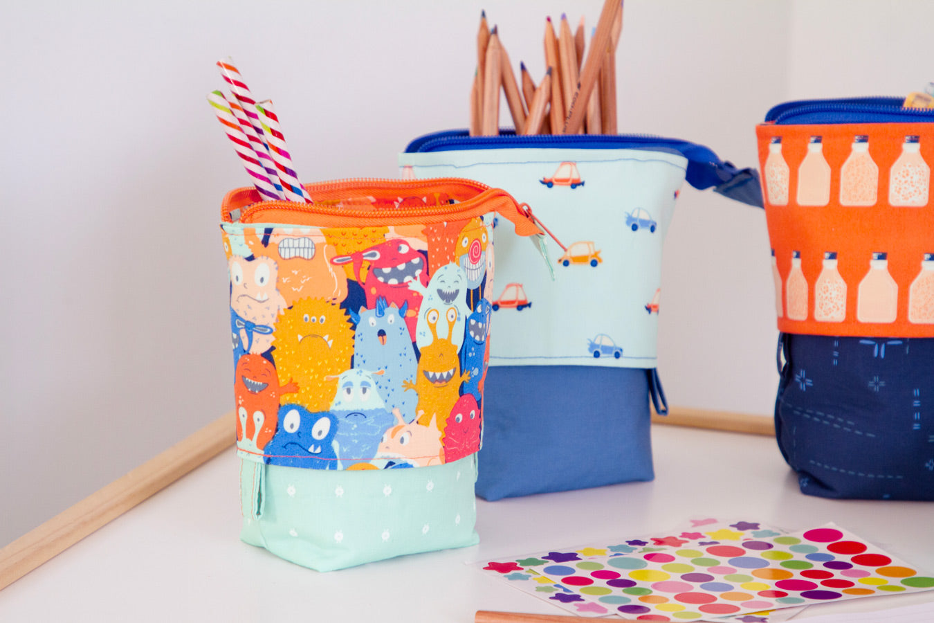 Three colorful fabric containers with different patterns on a white surface.