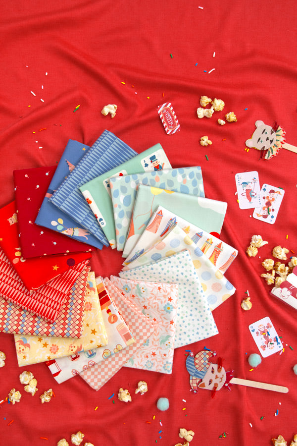 Collection of colorful fabric swatches on a red background with popcorn and cards.