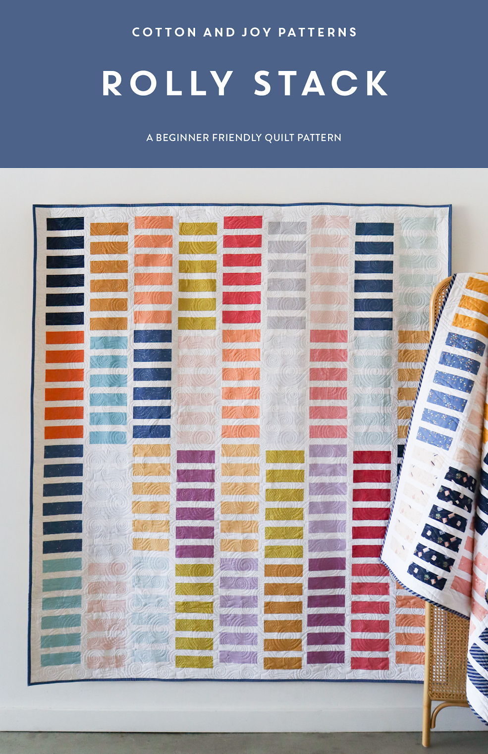 Quilt with colorful pattern on a white wall, featuring the brand 'Cotton and Joy'.