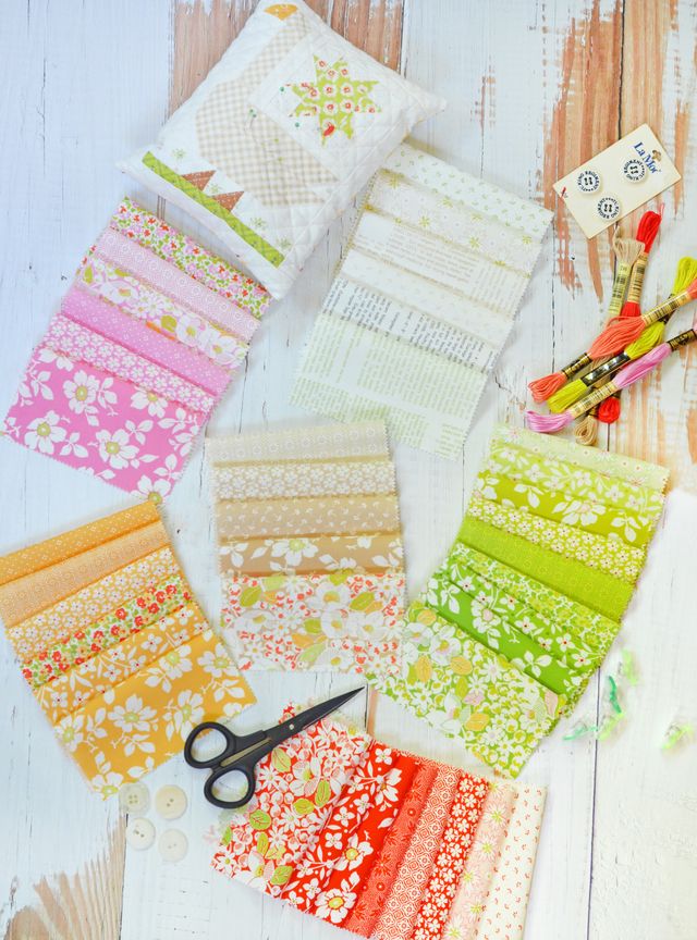 Collection of colorful fabric strips with a pair of scissors on a wooden surface