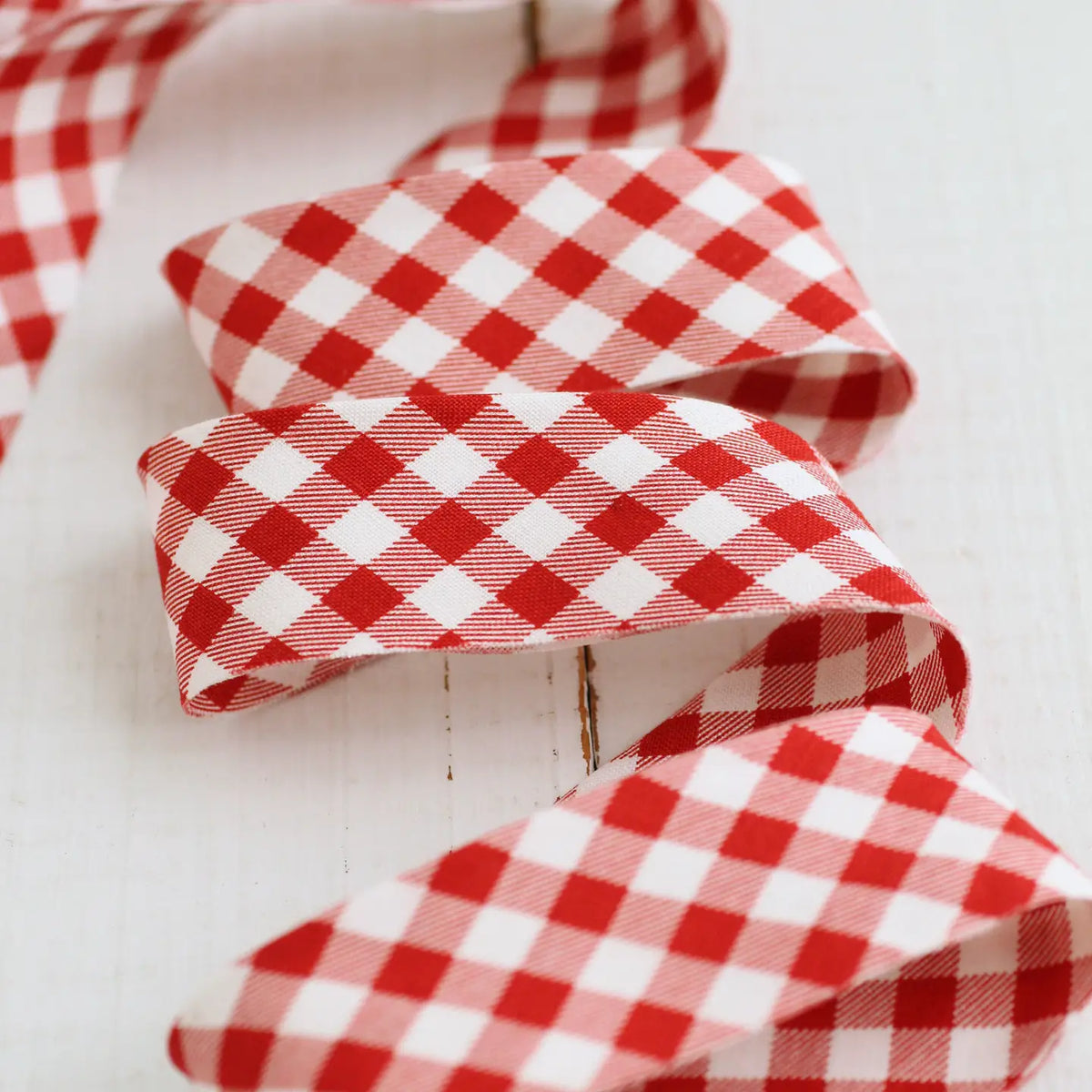 redd and white bias binding tape on a while table.
