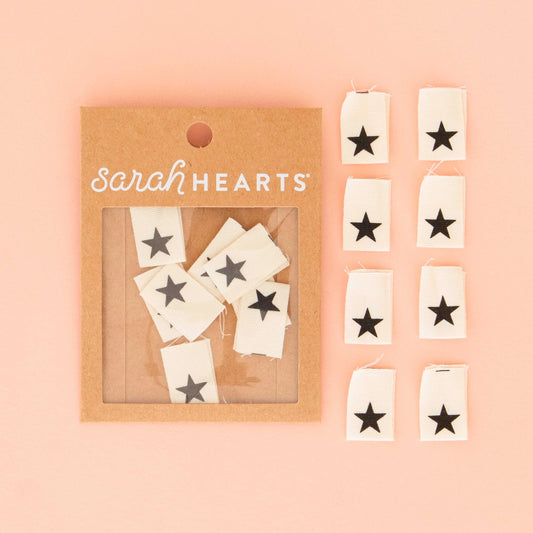 Packaged star-shaped tags with 'Sarah Hearts' branding on a pink background