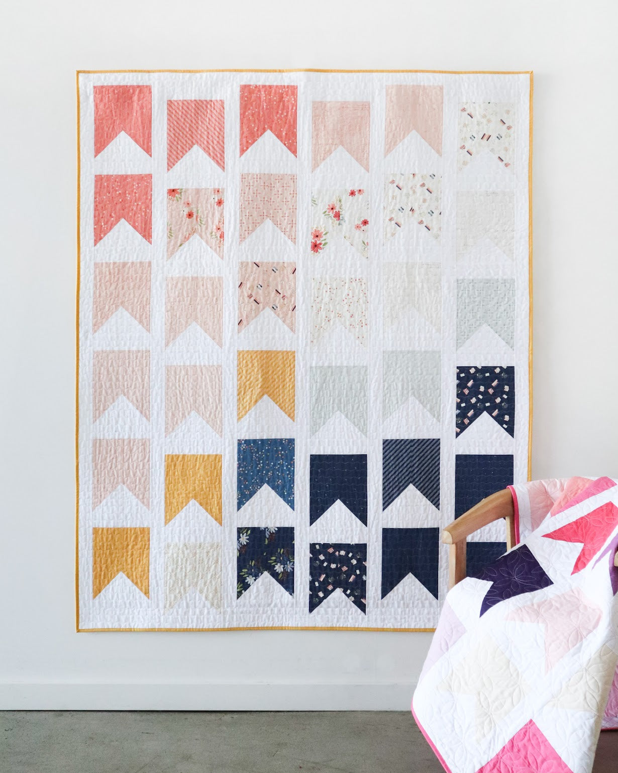 Colorful quilt with geometric pattern on a white wall