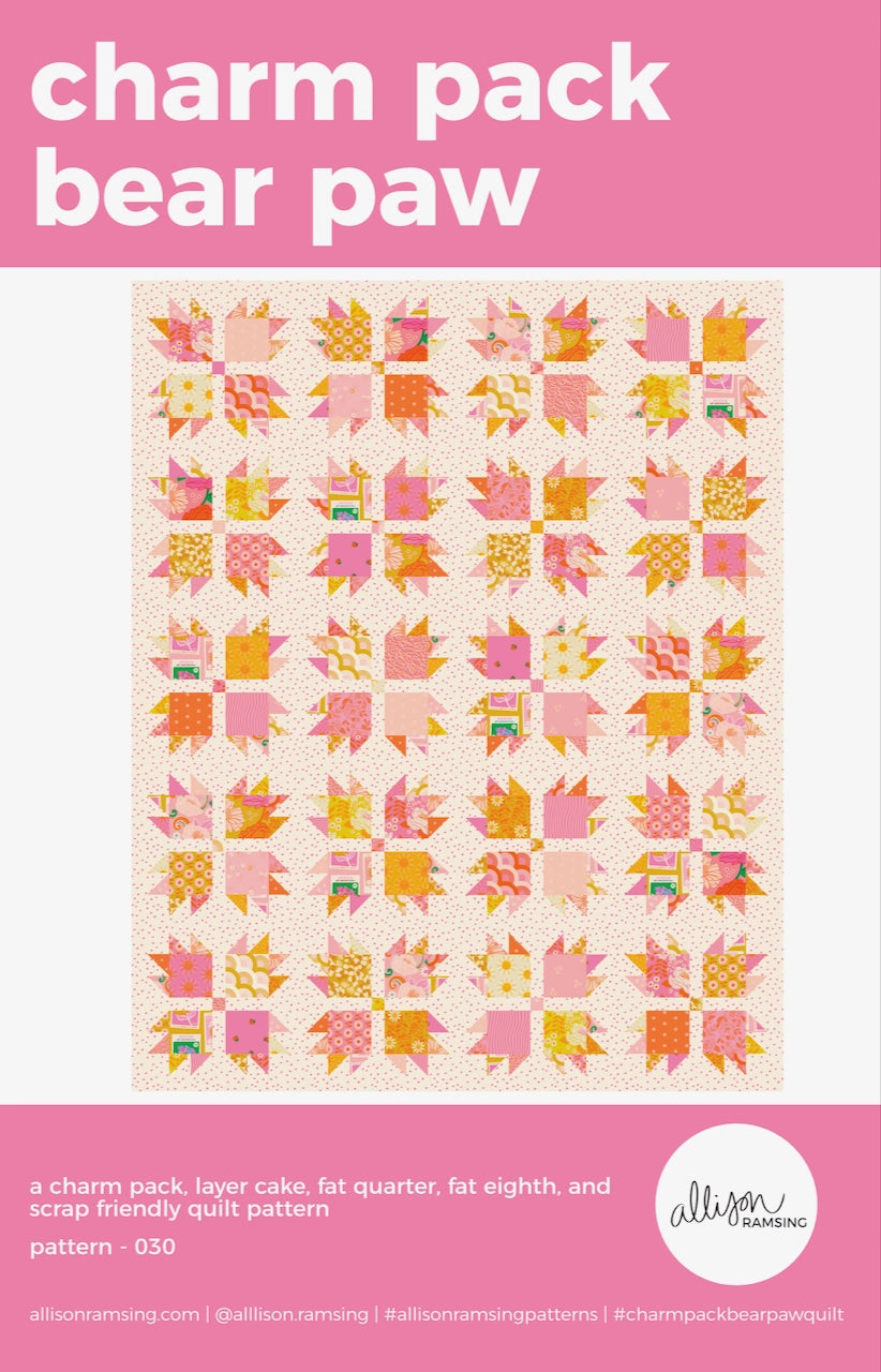 Quilt pattern cover with pink and orange bear paw design on a light background
