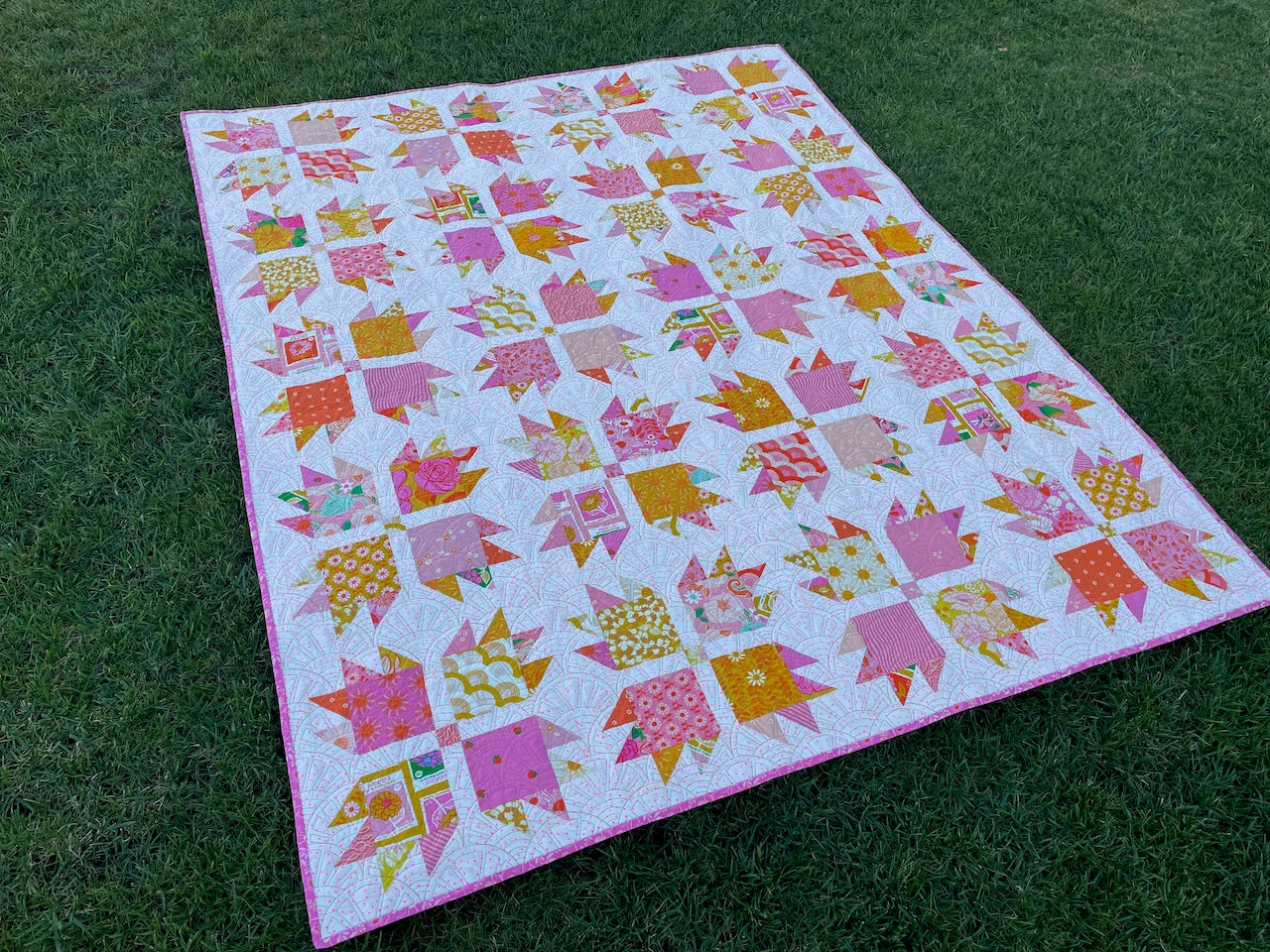 Colorful quilt with geometric pattern on grass