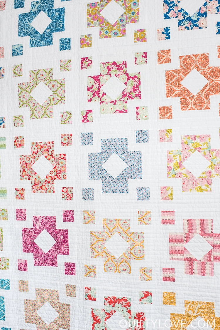 Colorful quilt pattern with geometric shapes on a white background