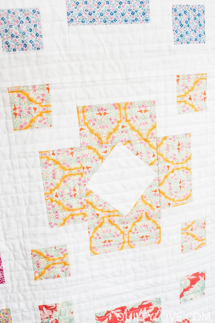 Quilt with colorful square patterns on a white background