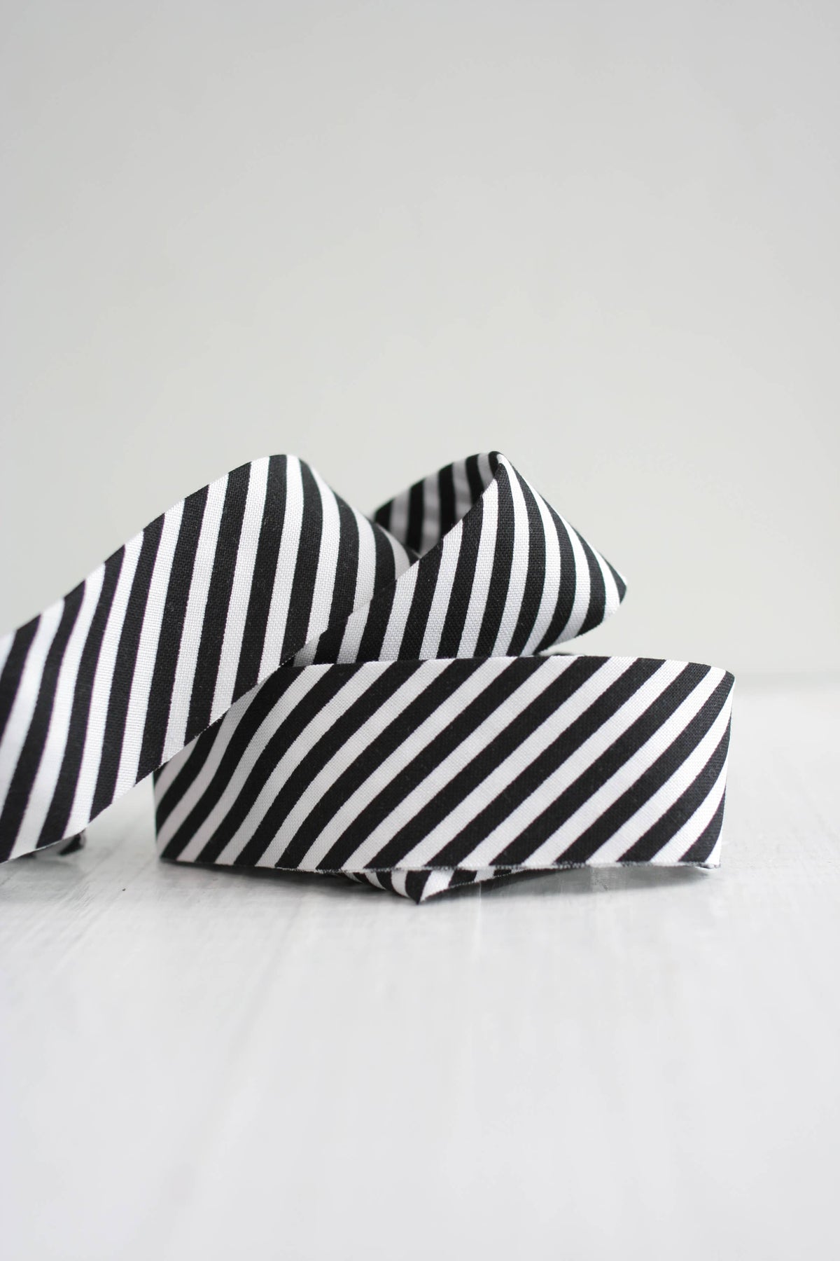 Black and white striped ribbon on a light gray background