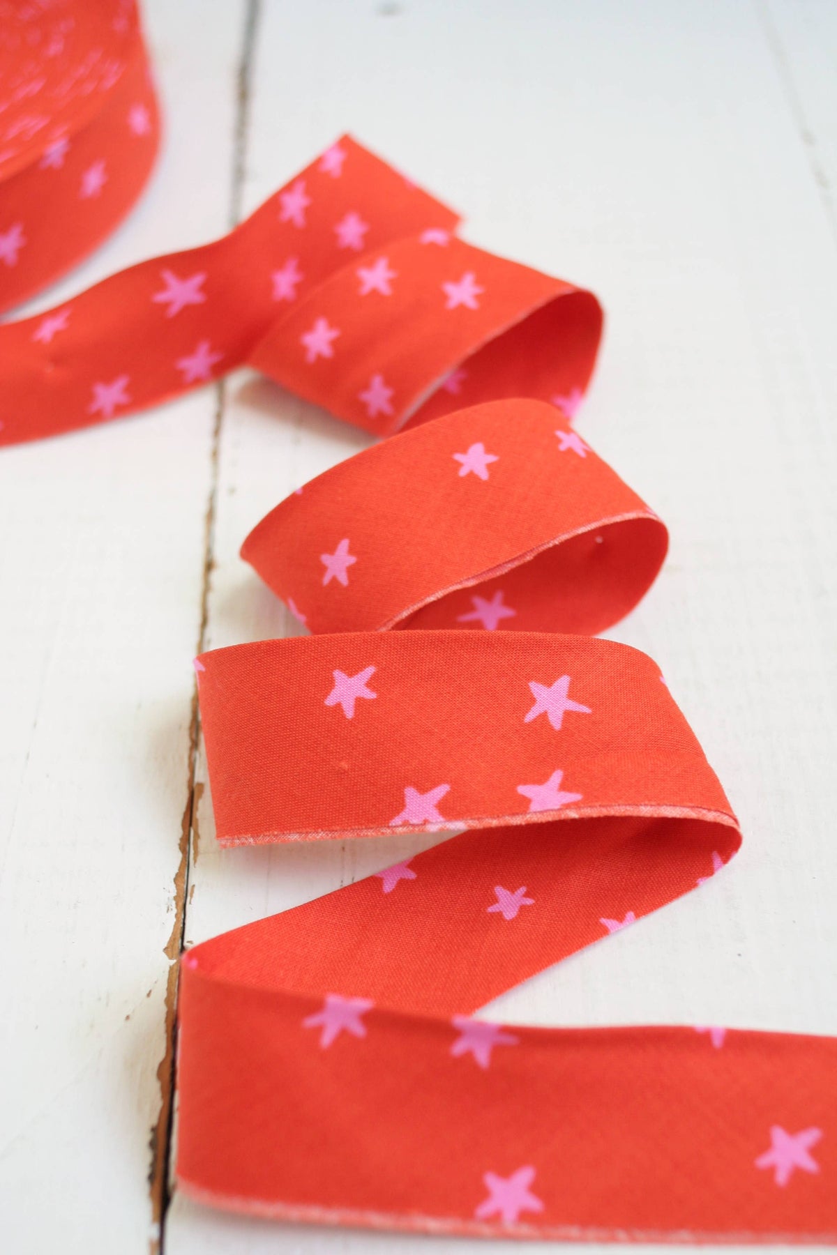 Red ribbon with pink star patterns on a white background