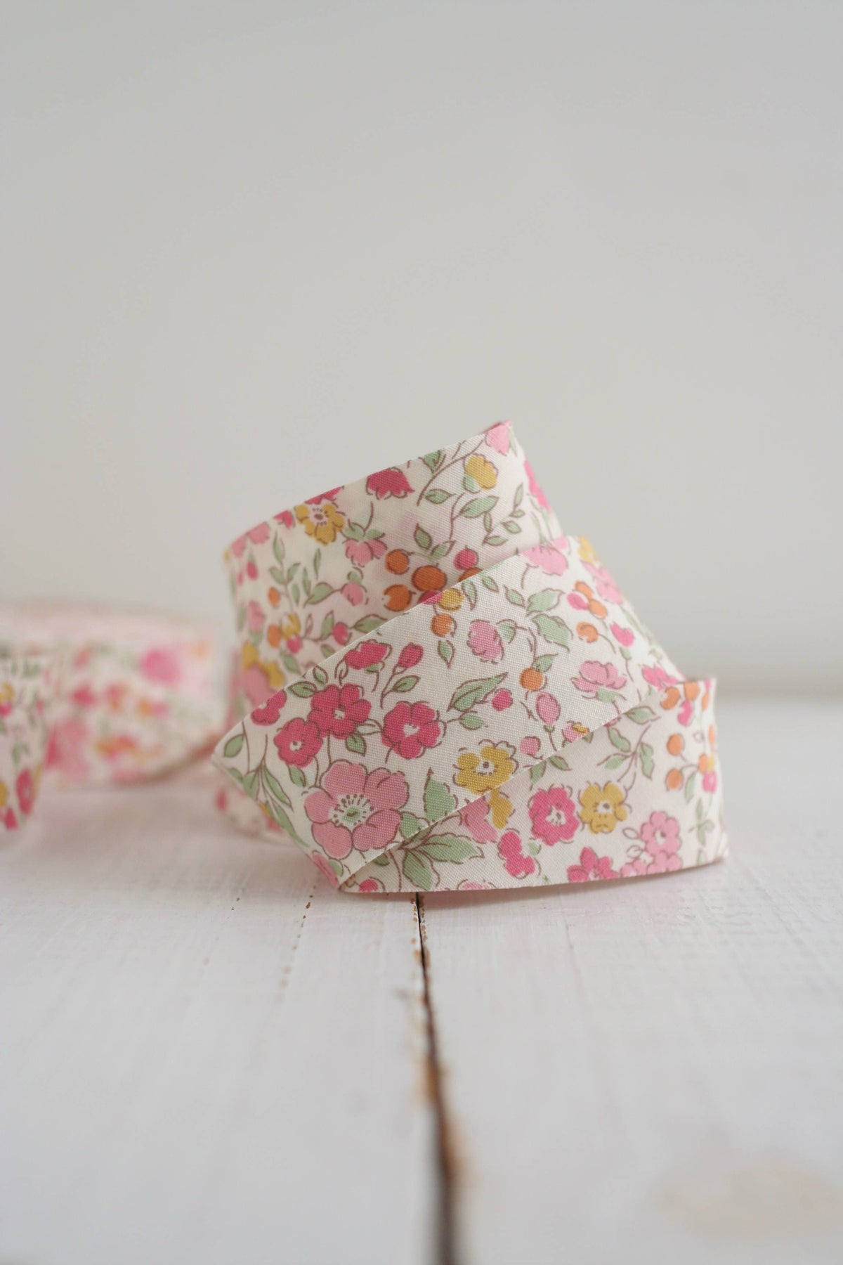 Floral-patterned fabric bias quilt binding  on a light wooden surface