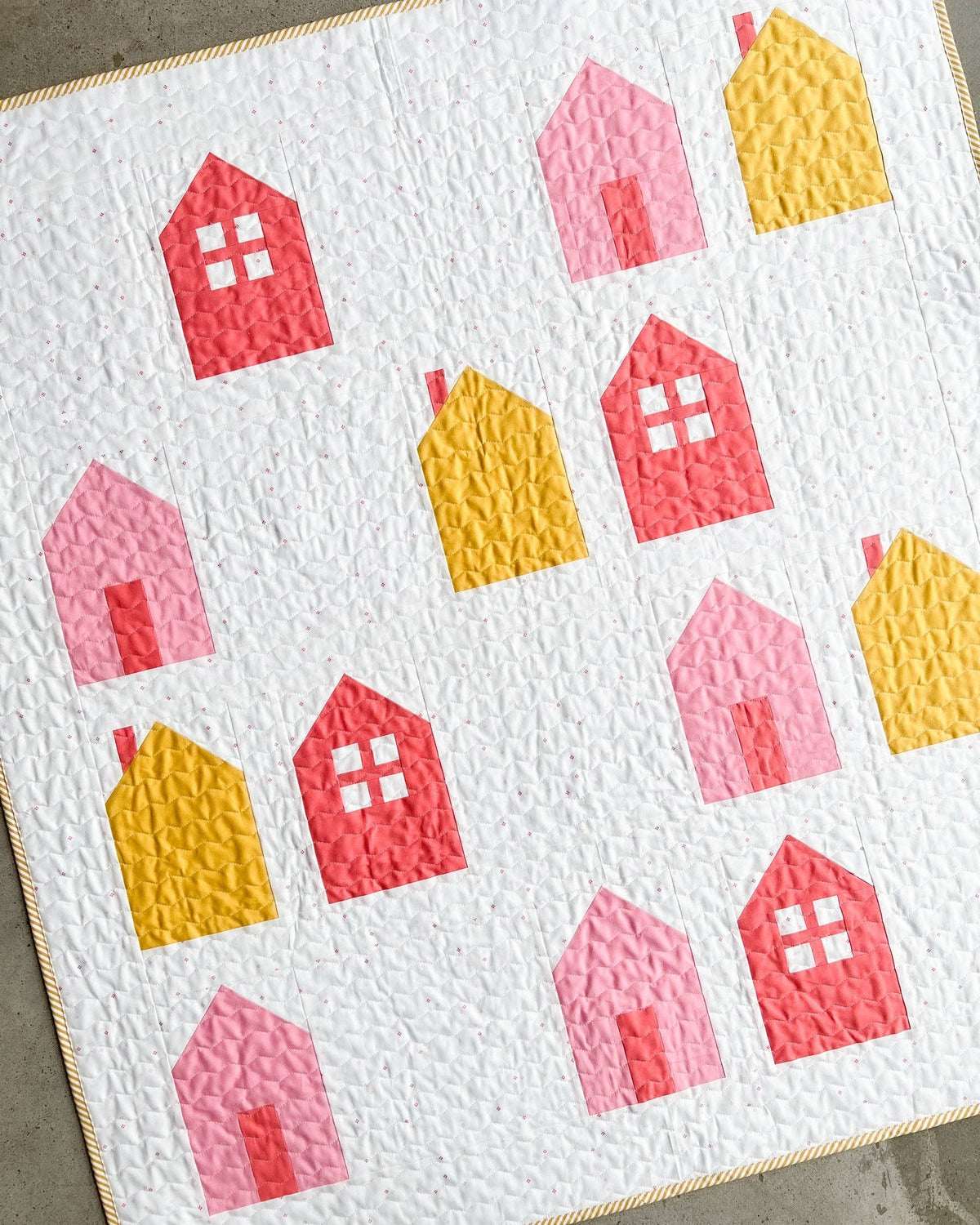 Quilt with colorful house patterns on a white background