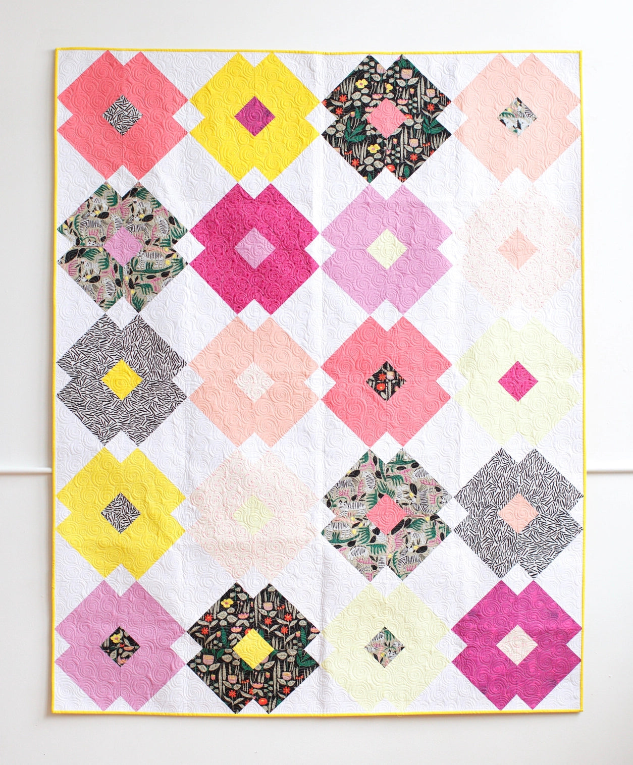 Colorful quilt with geometric pattern on a white background