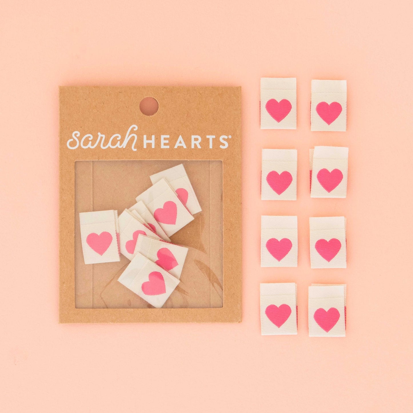 Packaging of 'Sarah Hearts' with heart tags on a pink background