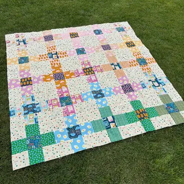Colorful patchwork quilt on a grassy background