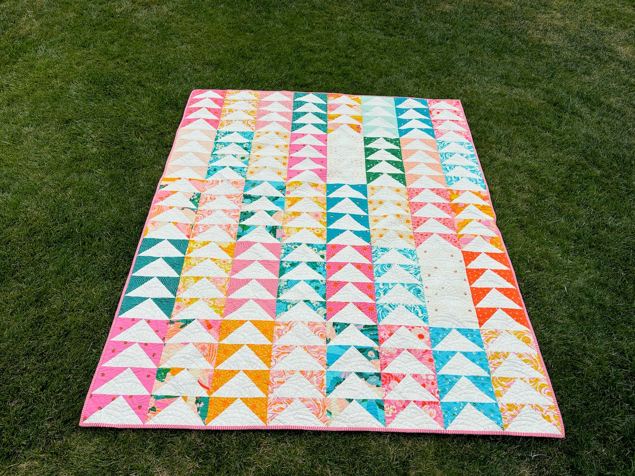 Colorful quilt with triangle pattern on grass