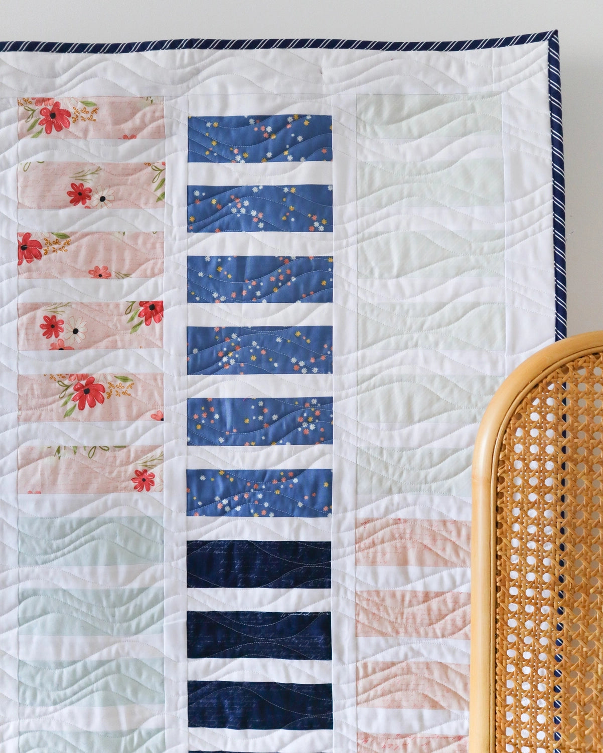 Quilt with floral and blue patterned panels on a white background