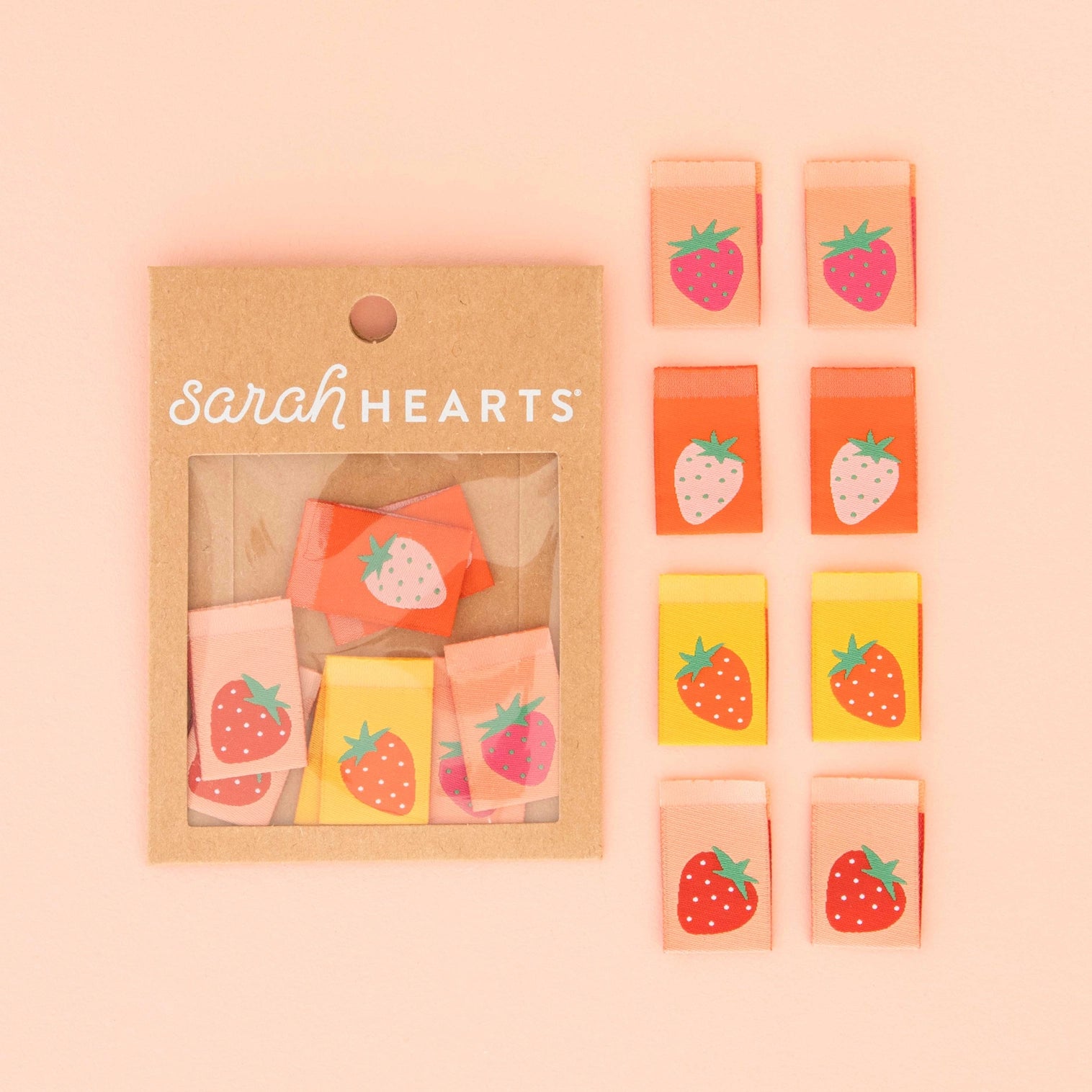 Packaged strawberry-themed items with 'sarah Hearts' branding on a pink background