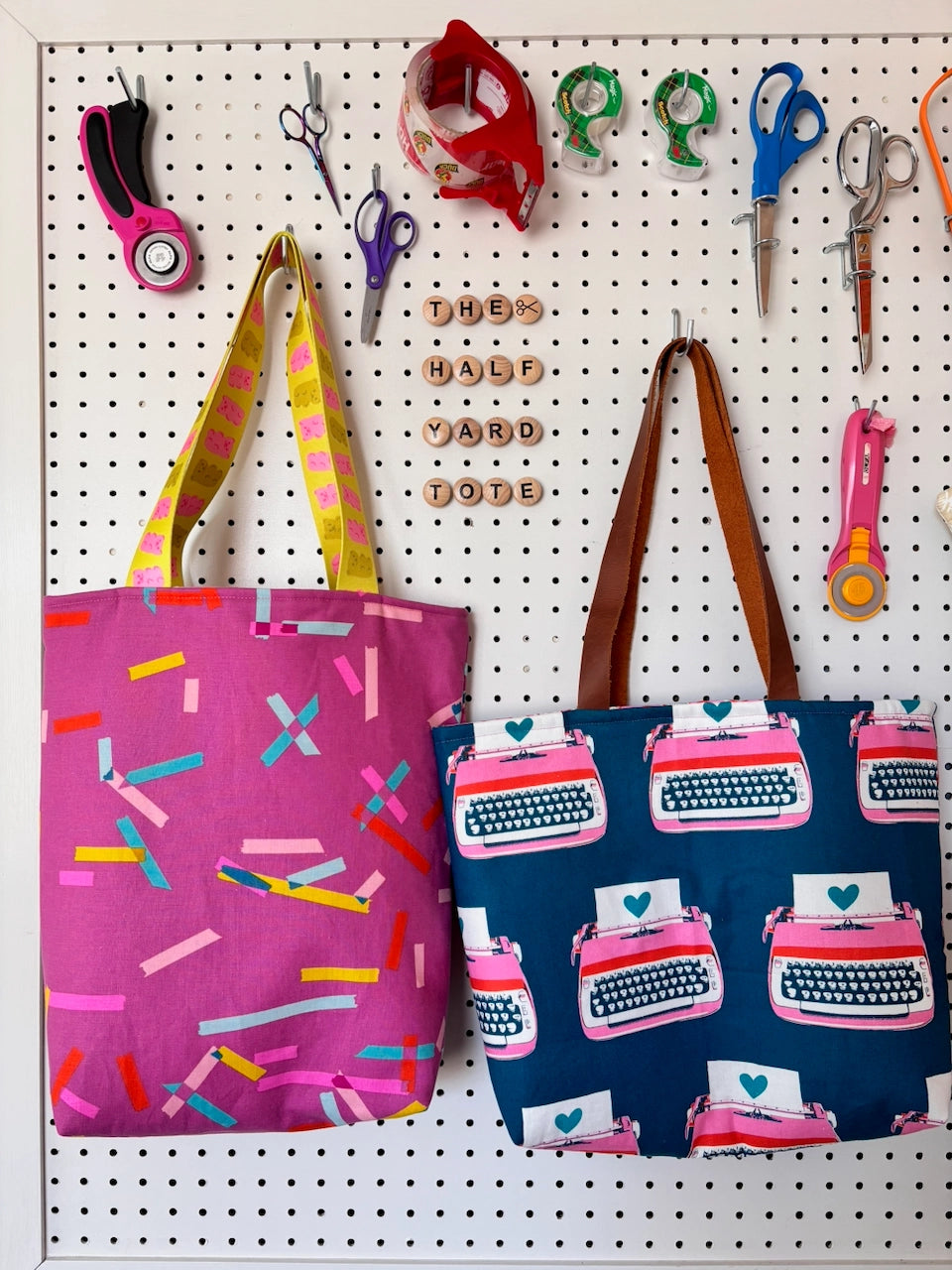 Two tote bags on a pegboard with various tools and tools labeled 'The Half Yard Love'.